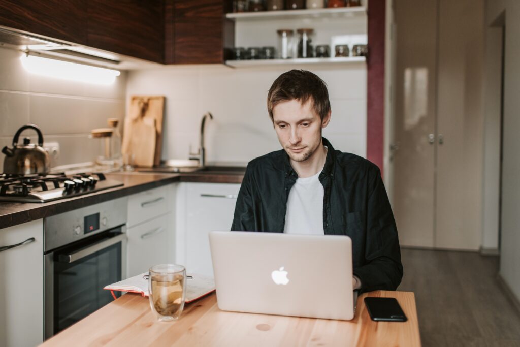 Man in Kitchen working on Laptop